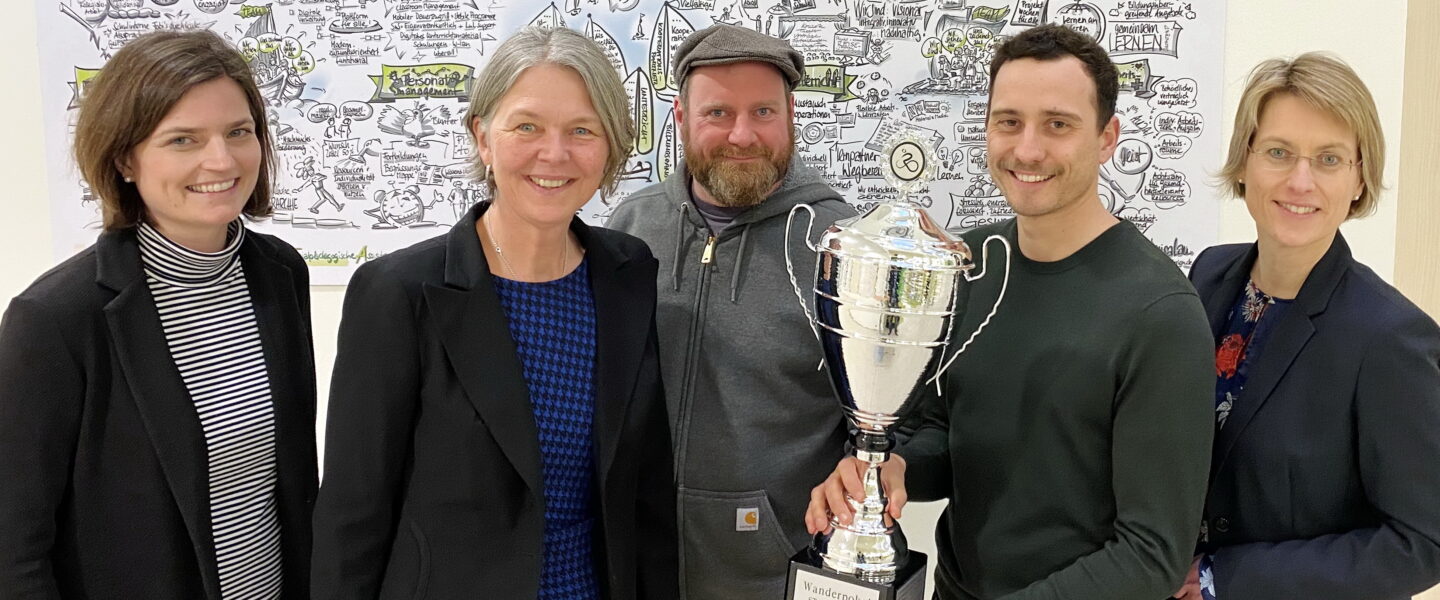 Stellvertretende Schulleiterin der BS 18 Anne Rauh-Wesseloh, Schulleiterin Wiebke Schuleit, Benedikt Fuss, Stefan Lütgert und Dr. Sandra Garbade mit dem Siegerpokal an der BS18.